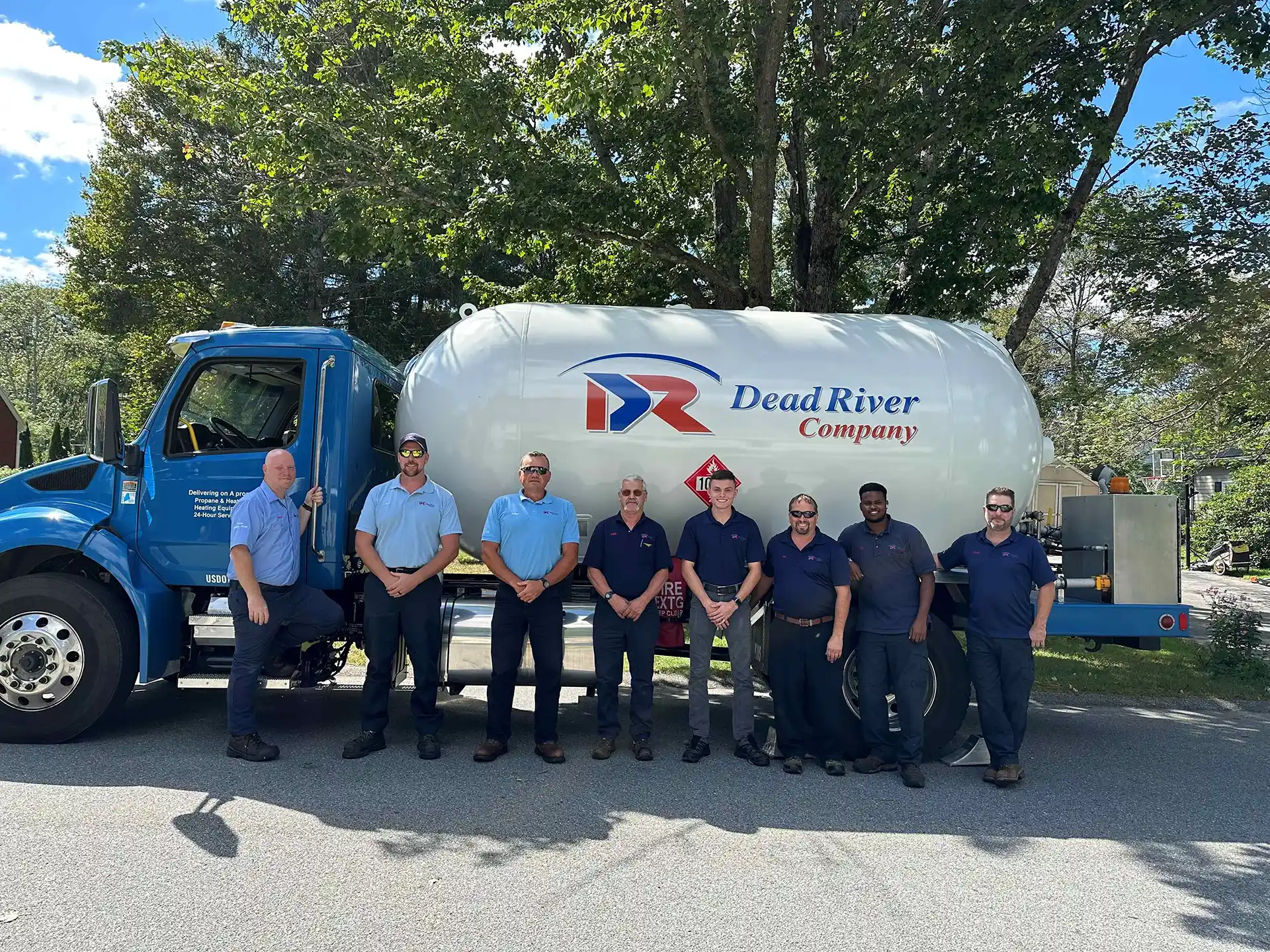 Smiling Dead River drivers & technicians standing in front of liquid propane delivery vehicle